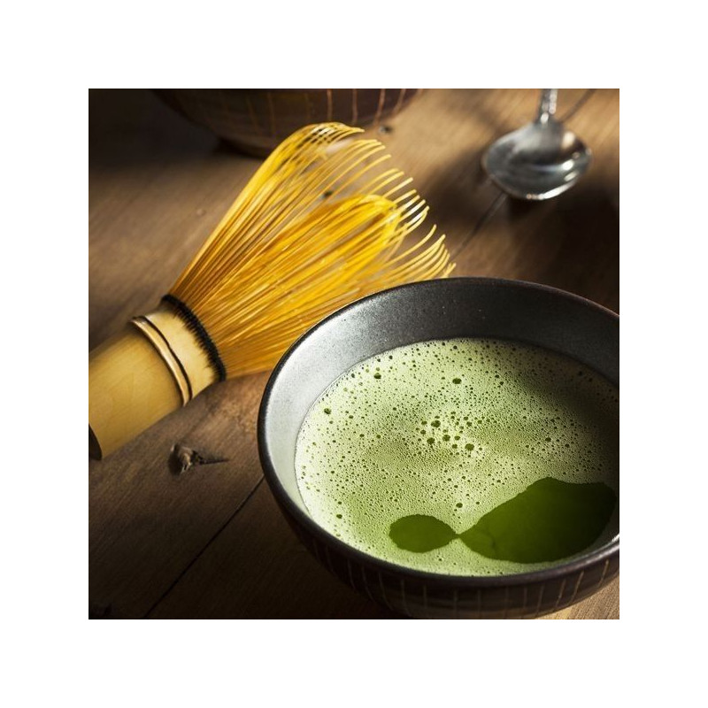 bamboe klopper voor traditionele bereiding van matcha thee met groen schuim in keramische kom