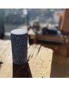 Cylindrical box in washi paper with white flower pattern on blue background placed on light wood table