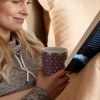Vrouw die een Andalusia Berry theemok met kleurrijke motieven vasthoudt tijdens het lezen van een boek in bed