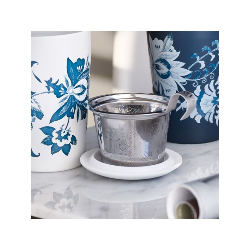 Stainless steel tea strainer with handle and white support placed on marble table