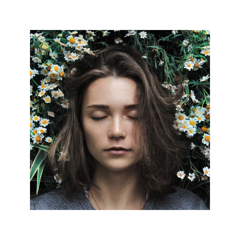 femme aux yeux fermés entourée de fleurs blanches et jaunes pour tisane CBD sommeil Thés & Traditions