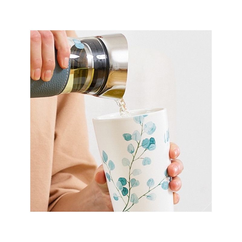 Teiera Tree Eucalyptus versa infuso in tazza bianca decorazione foglie blu