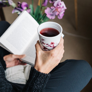 porcelain tea infuser mug cherry blossom pattern containing a reddish infusion