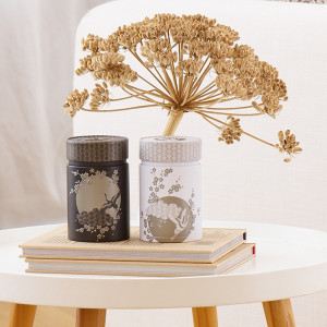 Komorebi-Dose 150g mit japanischen Motiven verziert, auf Büchern arrangiert mit getrockneter Pflanze im Hintergrund