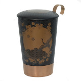 Zwarte Komorebi theekan met vogel- en gouden bloemenmotief en koperen metalen voet