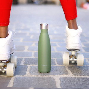 kaki roestvrijstalen thermosfles met zilveren dop op geplaveide grond tussen witte wieltjes