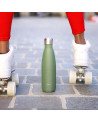 bouteille isotherme kaki en acier inoxydable avec bouchon argenté posée sur sol pavé entre patins à roulettes blancs