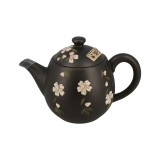 Tokoname theepot zwart met witte bloemmotieven en groene bladeren in traditioneel Japans keramiek