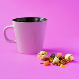 Witte kop met infusie amandelwolk kruidenthee stukjes gedroogd fruit en popcorn op roze achtergrond