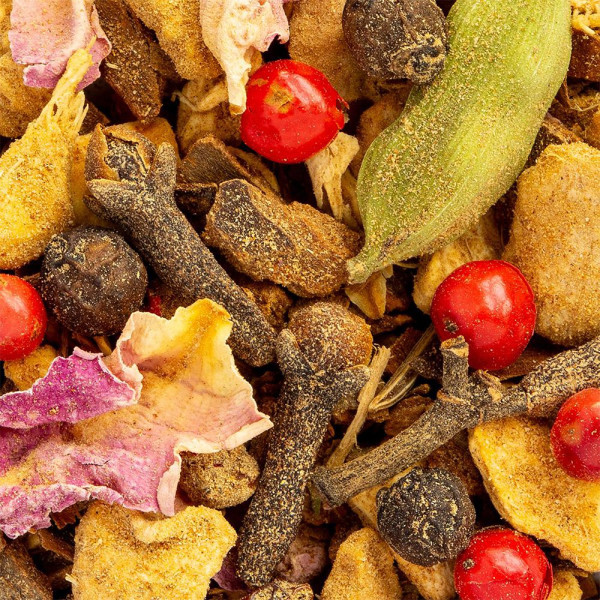 miscela di spezie e piante per tisana Chakra Chai con chiodi di garofano, bacche di cardamomo e petali di fiori