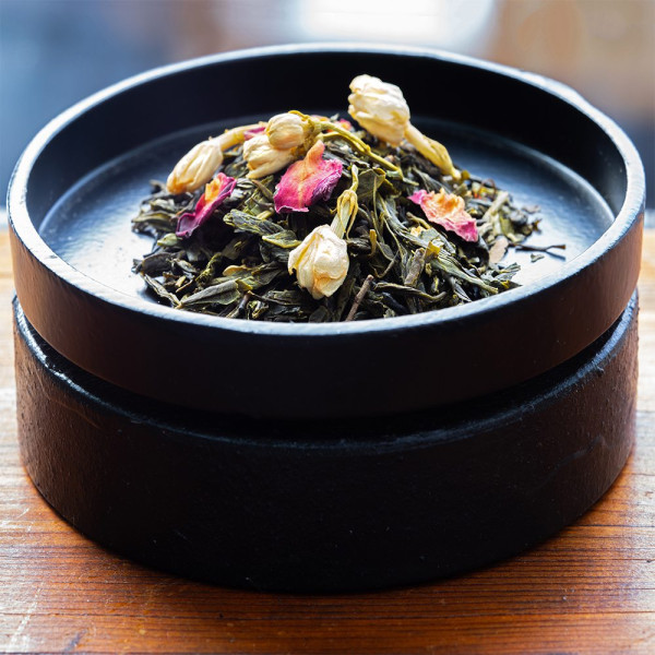 Night in Tokyo green tea with dried leaves and flowers on black wooden tray