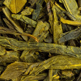 Gedroogde bladeren van groene thee Earl Grey Sencha in groene en bruine tinten