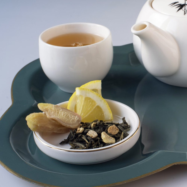 Tè verde Yangtze foglie secche zenzero limone fetta di zenzero teiera e tazza bianca