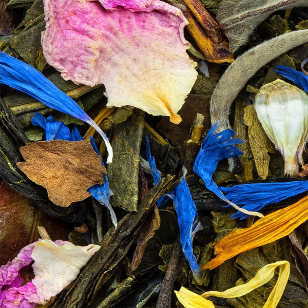 mélange de thé vert avec pétales de fleurs bleues roses jaunes et morceaux d'écorce pour infusion aromatique