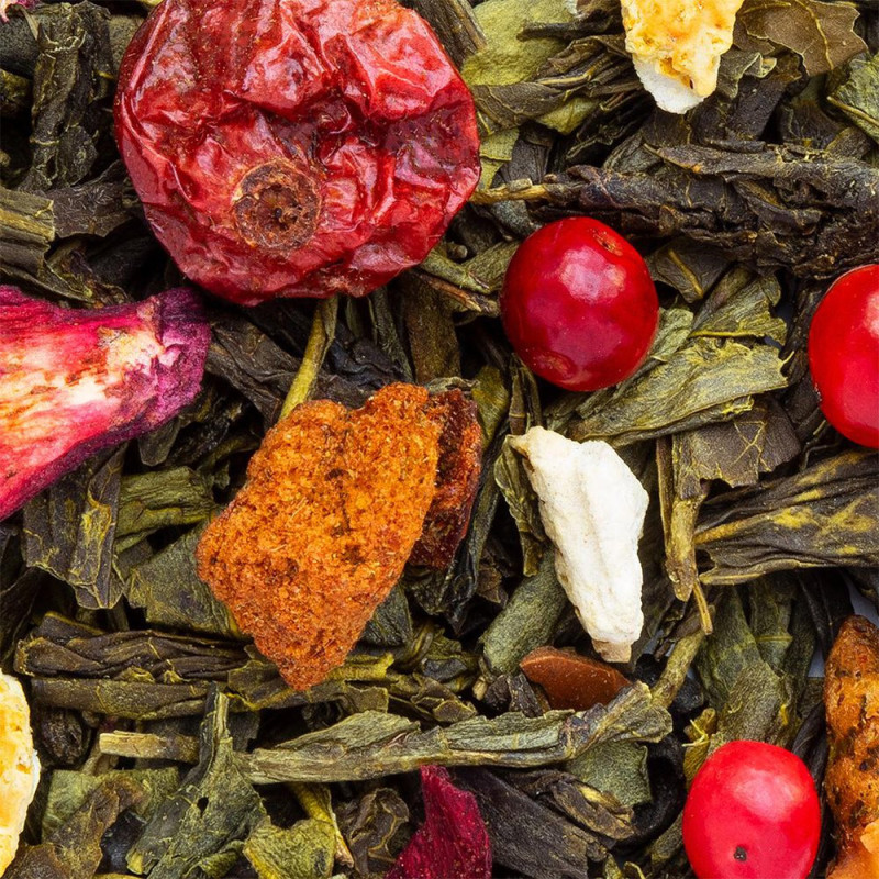 Mischung aus grünem Tee, getrockneten Blättern, roten Beeren, Fruchtstücken und Blüten