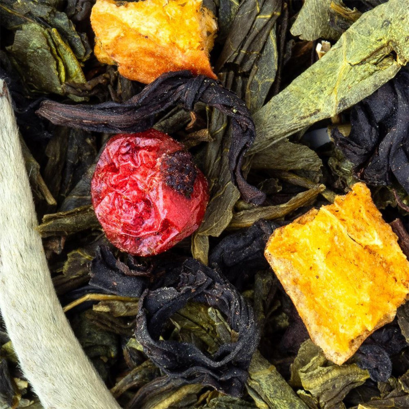 Mischung aus grünem Tee, getrockneten Blättern, Zitrusfruchtstücken und roten Beeren
