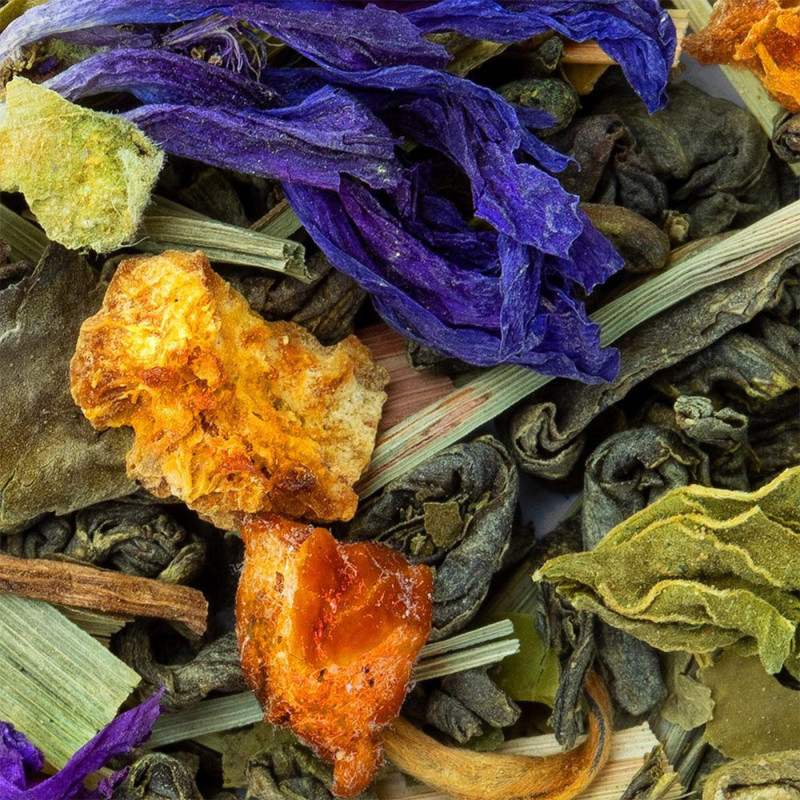 mélange de thé vert feuilles séchées fleurs violettes et morceaux d agrumes pour infusion énergisante
