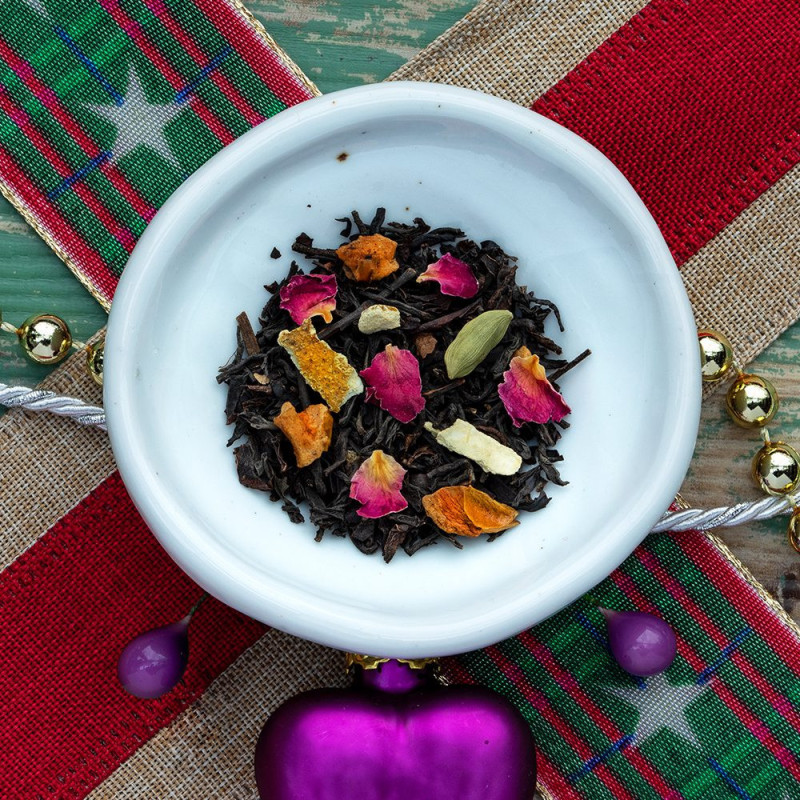 mélange de thé noir aux pétales de rose écorces d'orange et épices de Noël dans assiette blanche