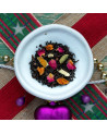 mélange de thé noir aux pétales de rose écorces d'orange et épices de Noël dans assiette blanche