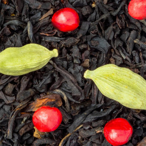 Tè nero in foglie con bacche rosse e capsule di cardamomo verde pistacchio