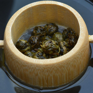 perle di tè bianco al gelsomino Dragon Pearls in infusore di bambù su sfondo nero