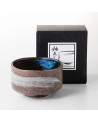 Bol à matcha brun avec motif blanc et intérieur bleu accompagné d'une boîte noire