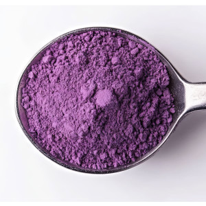 poudre ube violette fine dans une cuillère métallique sur fond blanc