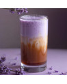 Boisson lactée violet et marron avec poudre ube et fleurs violettes autour