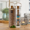 Glass teapot with Leo character infuser and leopard print cover on wooden table