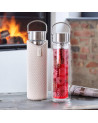 Glaskanne Flowtea Amami mit Blumenmuster-Sieb und beiger Schutzhülle auf Holztisch