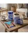 Teedose Côte d'Azur in Blau mit floralen Motiven und Landschaftsmuster neben loser Tee auf Holztisch