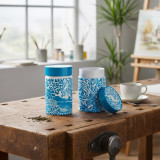 Boite à thé turquoise motif floral Côte d'Azur Thés et Traditions ouverte et fermée sur table en bois