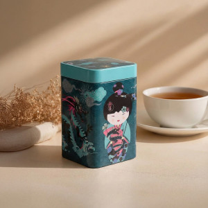 Teedose Sweet Little Geisha Water mit Geisha- und Drachenmotiv und Teetasse im Hintergrund