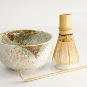 Keramikschale mit Bambusquirl und traditionellem Löffel zur Matcha-Zubereitung