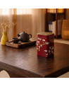 Theeblik Japan 100g rood met witte bloemenversiering op houten tafel met traditioneel theeservies