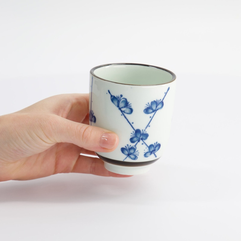 Tazza in porcellana bianca decorata con fiori blu tenuta in mano capacità 16 cl
