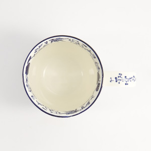 Weiße Tasse mit japanischem Blumenmuster und blauem Kranich, Henkel mit blauen Beeren verziert