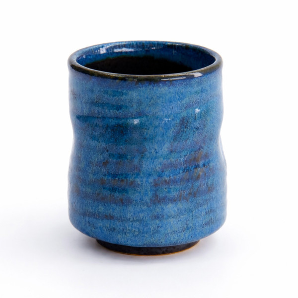 Artisanal blue ceramic cup with glossy finish and irregular rounded shape