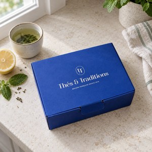 Coffret Detox Thés & Traditions : écrin bleu sur un plan de travail clair, avec citron, menthe fraîche et thé vert