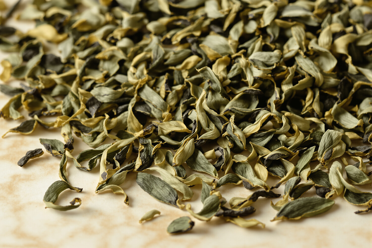 Feuilles d'oolong torsadées en gros plan sur marbre crème