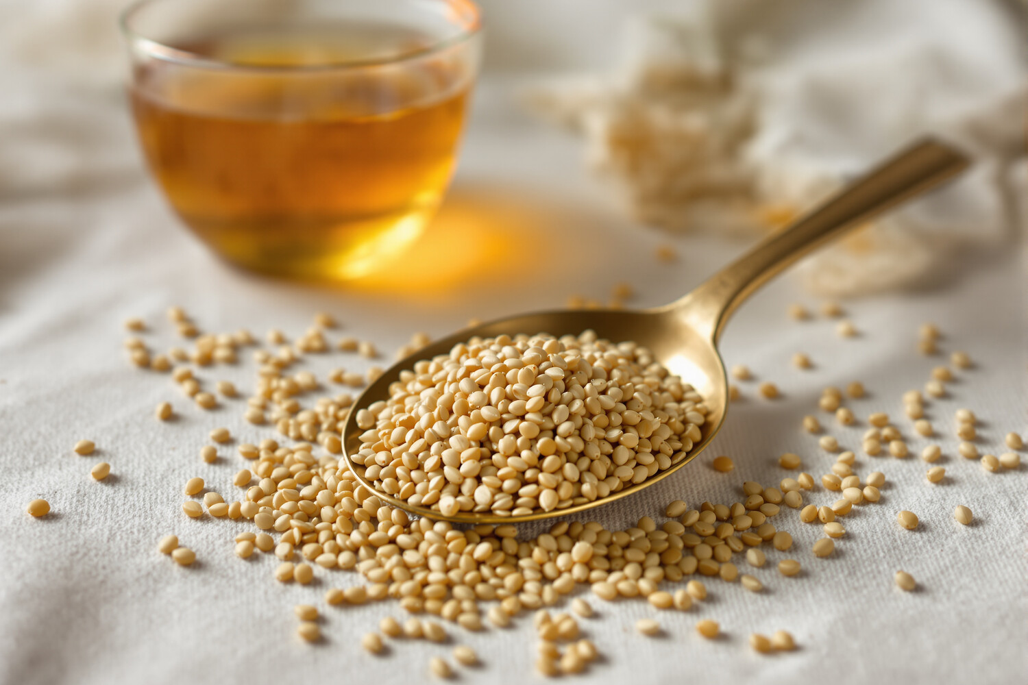 Cuillère en laiton remplie de graines de fenouil et tasse d'infusion
