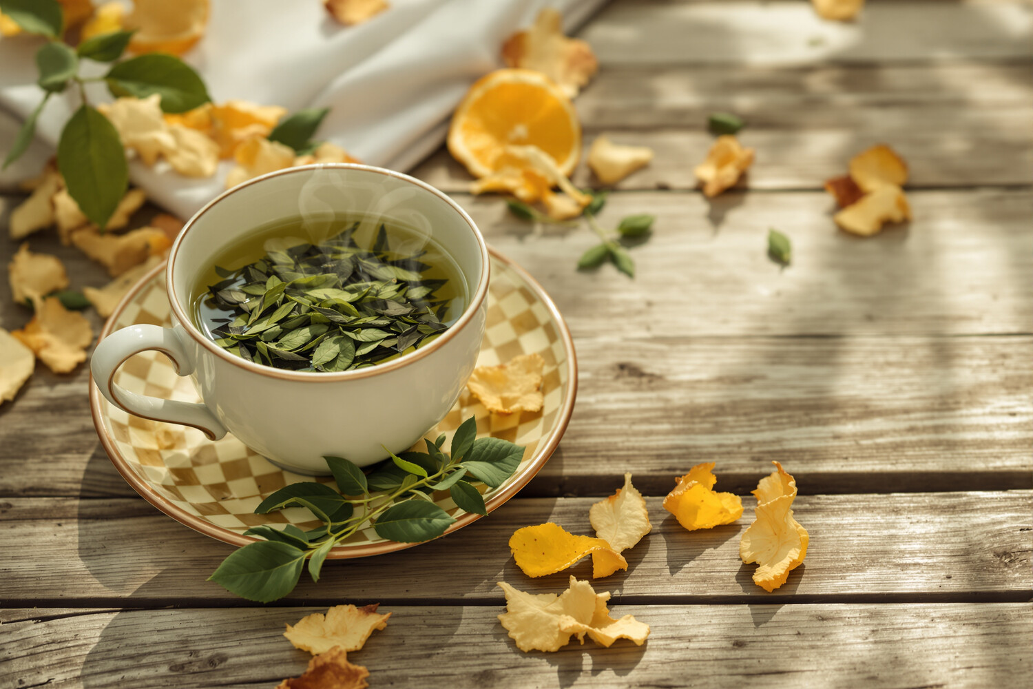 Tazza fumante di tè verde detox e foglie d'autunno su tavolo di legno