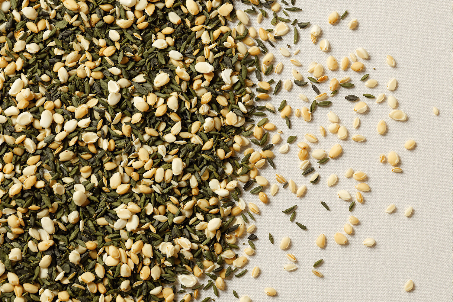 Gros plan de feuilles de thé vert sencha mêlées à des grains de riz soufflé dorés sur lin écru.