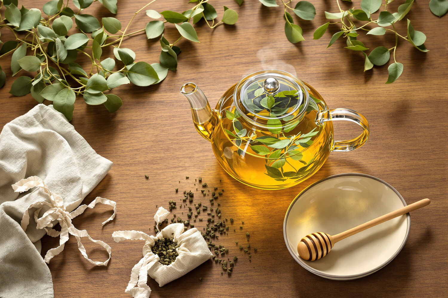 Amber glass teapot with a golden lemon balm infusion, surrounded by fresh sprigs and a linen pouch on raw wood.